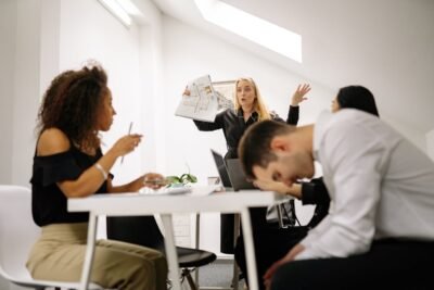 Na imagem, equipe em situação de estresse e pressão no ambiente corporativo
