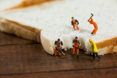 Trabalhadores de minutas que trabalham em fatias de pão